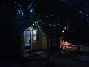 a house at night with trees in front of it at By The C' Cabanas in Hikkaduwa