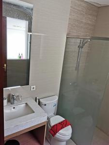 y baño con aseo, lavabo y ducha. en Bukit Jaya Residence & Apartment Semarang en Semarang