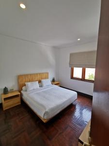 una camera da letto con un letto con lenzuola bianche e una finestra di Bukit Jaya Residence & Apartment Semarang a Semarang