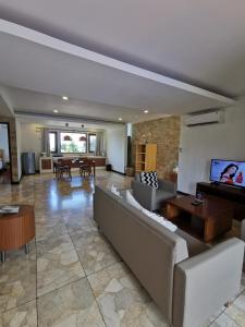 Bukit Jaya Residence & Apartment Semarang في سيمارانغ: غرفة معيشة كبيرة مع أريكة وطاولة