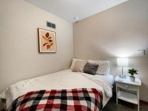 a bedroom with a bed with a plaid blanket at Chic 2br - 2 Min From Icubs in Des Moines