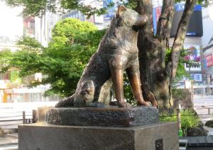 posąg psa stojącego obok drzewa w obiekcie APA Hotel Shibuya Dogenzakaue w Tokio
