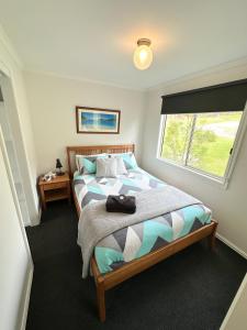 een slaapkamer met een groot bed en een raam bij Tidal Dreaming Seaview Cottages in Yanakie
