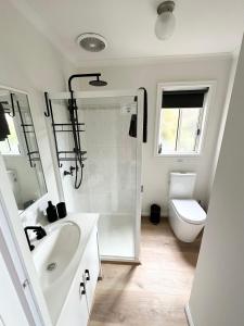 a bathroom with a shower and a sink and a toilet at Tidal Dreaming Seaview Cottages in Yanakie