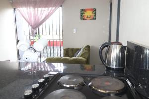 a kitchen with a stove top oven in a room at Karaboapartlodge in Jane Furse