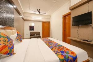 a bedroom with a bed and a flat screen tv at FabHotel Neena Palace in Bhopal