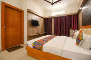 una camera d'albergo con letto e TV di FabHotel Neena Palace a Bhopal