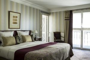 a bedroom with a large bed and a window at Hôtel Brighton - Esprit de France in Paris