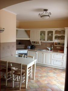 a kitchen with white cabinets and a table at Nyugalom Szigete Vendégház SZIGLIGET in Szigliget
