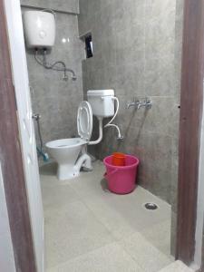 a bathroom with a toilet and a shower and a bucket at Deepjen Homestay in Darjeeling
