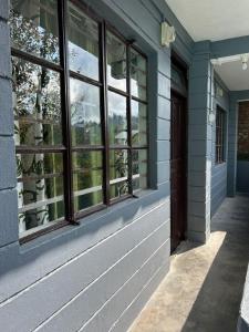 ein blaues Gebäude mit Fenstern und einer Tür in der Unterkunft Deepjen Homestay in Darjeeling