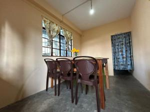 uma sala de jantar com uma mesa e cadeiras e uma janela em Deepjen Homestay em Darjeeling