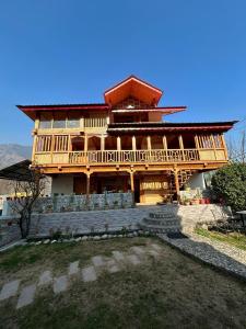 una gran casa de madera con escaleras delante en BARFI MANALI, en Manali