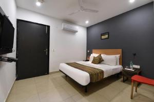 a bedroom with a bed and a black wall at Hotel Orchid Saffron at Janakpuri in New Delhi