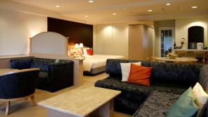 a hotel room with a bed and a living room at Hotel Cypress Karuizawa in Karuizawa