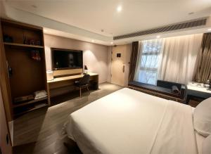 une chambre d'hôtel avec un lit et une télévision dans l'établissement Atour Hotel Beijing Chaoyangmen, à Pékin
