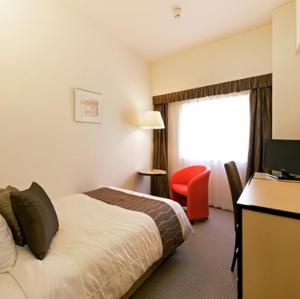 a hotel room with a bed and a television at The Celecton Fukushima in Fukushima