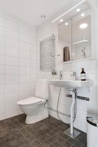 a white bathroom with a toilet and a sink at Guestly Homes - 1BR Corporate Comfort in Boden