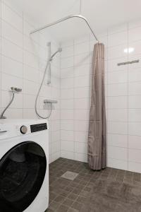 a washing machine in a bathroom with a shower at Guestly Homes - 1BR Corporate Comfort in Boden