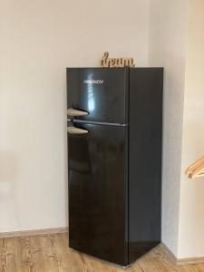 un frigorifero nero nell'angolo di una stanza di cozy Apartment/WLAN in Neustadt i. Sachsen a Neustadt in Sachsen