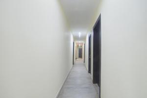 a corridor of a hallway with white walls and a long hallway at FabHotel Magadh Crystal in Patna