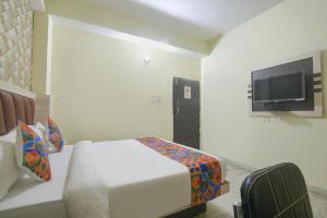 um quarto com uma cama e uma televisão de ecrã plano em FabHotel Magadh Crystal em Patna