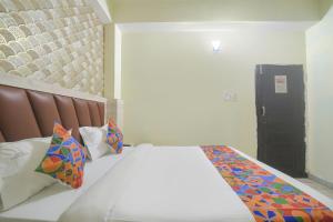 um quarto com uma cama grande e almofadas coloridas em FabHotel Magadh Crystal em Patna