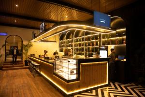 a restaurant with a bar with people standing around it at Vintclub Resort in Lucknow