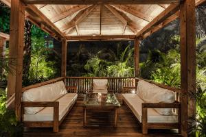 a wooden pergola with two couches and a table at Vintclub Resort in Lucknow