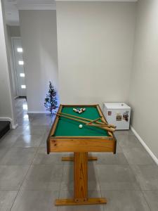 Truganina的住宿－Cosy Room with Lock, TV & Private Toilet，一张带球的台球桌和圣诞树