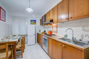 a kitchen with wooden cabinets and a sink and a table at Eleonora House - Happy Rentals in Alassio