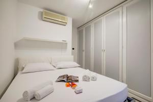 a white bedroom with a bed with towels on it at Eleonora House - Happy Rentals in Alassio