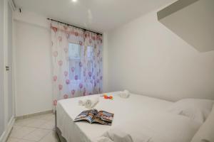 a bedroom with a white bed with a curtain at Eleonora House - Happy Rentals in Alassio