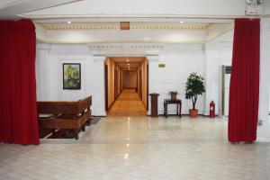 an empty room with red curtains and a hallway at Dansavanh Vientiane Hotel in Vientiane