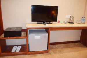 a desk with a television and a computer on it at Dansavanh Vientiane Hotel in Vientiane