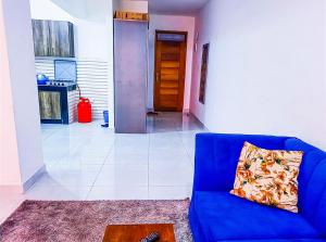 eine blaue Couch in einem Wohnzimmer mit einem Tisch in der Unterkunft Lovely and spacious studio along Mbs-Malindi Hwy near Nyali Center in Mombasa