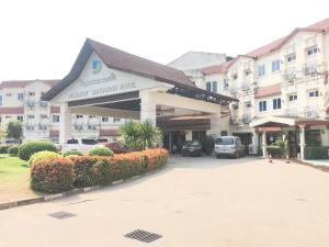 um edifício com carros estacionados num parque de estacionamento em Dansavanh Vientiane Hotel em Vientiane