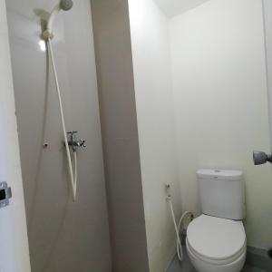 a bathroom with a white toilet and a shower at BR Room at Apartemen Bogorienze Resort in Pamoyanan