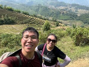 a man and a woman standing on a hill at SaPa Big Tree Hmong Homestay in Sa Pa