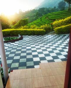 a checkered floor with a view of a tea plantation at Blackcherry Munnar in Munnar