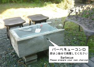 kamienny grill z dwoma krzesłami i ławką w obiekcie Rino to Hiroto no Himitsukichi - Vacation STAY 92317v w mieście Minamiizu