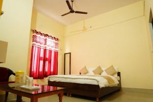 a bedroom with a bed and a ceiling fan at Atithi Hotel in Paliā Kalān +6 photos