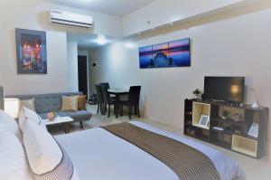um quarto de hotel com uma cama e uma sala de estar em Eighty One Building C53J Condotel em Manila