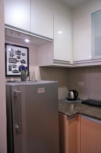 uma cozinha com frigorífico e armários brancos em Eighty One Building C53J Condotel em Manila