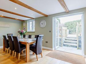 a dining room with a table and chairs and a clock at 4 Bed in Looe 82227 in Saint Cleer