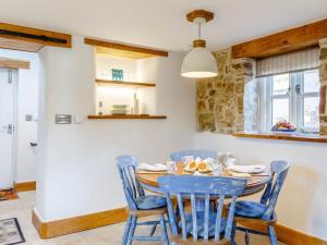 a dining room with a wooden table and blue chairs at 2 Bed in Bishops Tawton 79393 in Bishops Tawton