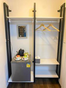 um pequeno frigorífico num quarto com uma prateleira em Baan Nimit Resort 
