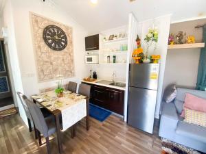 eine Küche mit einem Tisch und einem Kühlschrank in der Unterkunft Baan Nimit Resort 