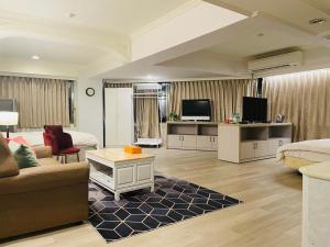 a living room with a couch and a tv at Felicity Business Hotel in Taichung