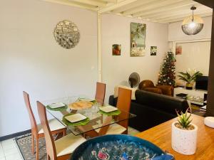 Sala de estar con mesa de comedor y árbol de Navidad en Lagon, Plage & Détente à La Saline les bains, en La Saline-Les-Bains